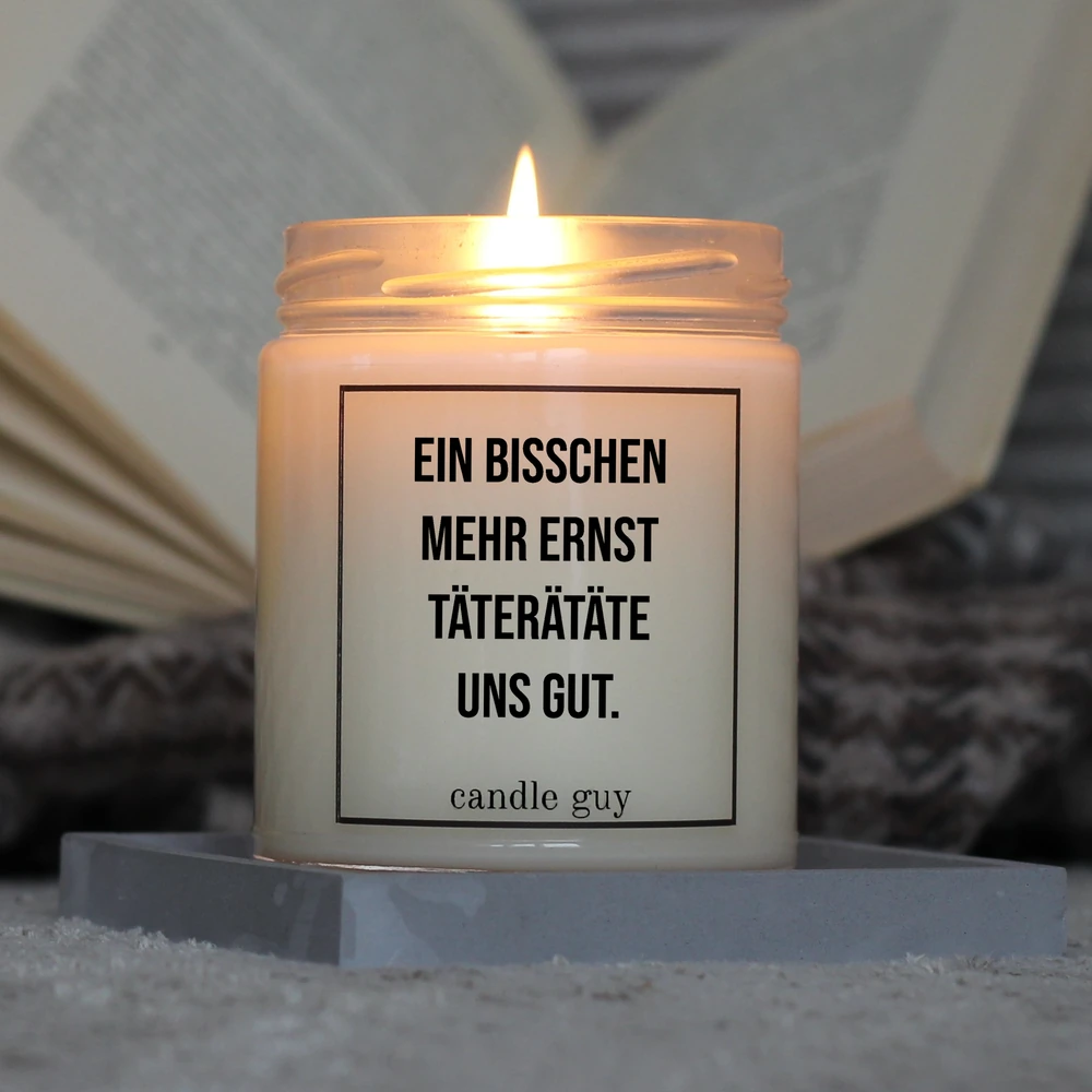 candle guy Duftkerze mit dem Spruch "Ein bisschen mehr Ernst täterätäte." in Aktion – brennt über 70 Stunden