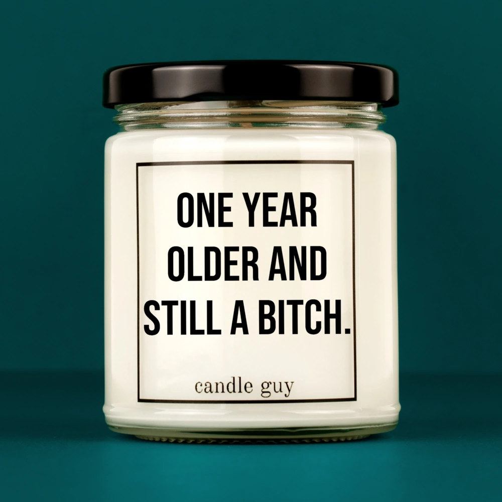 Candle Guy slogan candle: One year older and still a bitch. – minimalist in design, strong in message.