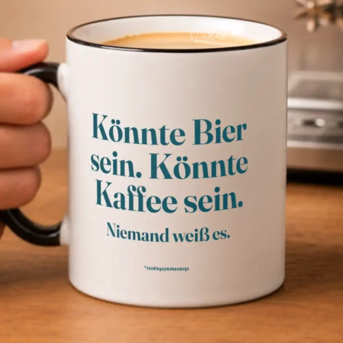 White ceramic mug held by a hand with teal German text: 'Könnte Bier sein. Könnte Kaffee sein. Niemand weiß es.'